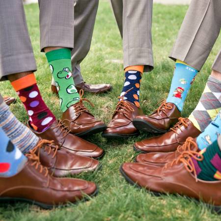 wedding party holding pant leg up to show colored socks