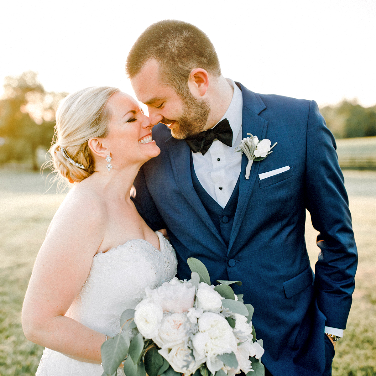 groom and bride in a field smiling